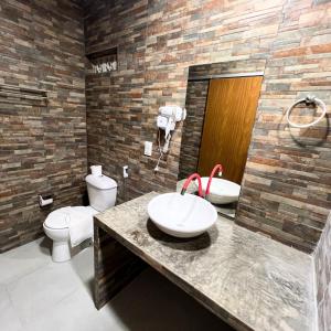 a bathroom with a sink and a toilet at Pousada Villa Bougainville Maragogi in Maragogi