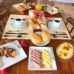 a table with plates of food and cups of coffee at Pousada Villa Bougainville Maragogi in Maragogi +37 photos