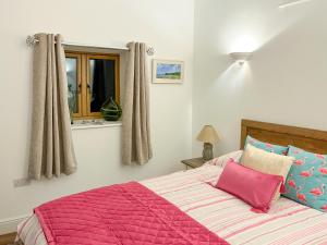 sypialnia z łóżkiem z różową kołdrą w obiekcie Maggies Place w mieście Holsworthy