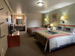 a hotel room with two beds and a sink at Antlers Lodge in Cooke City