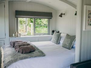 un dormitorio con una cama blanca con animales de peluche en Mimis Meadow-uk36576, en Milton Abbot