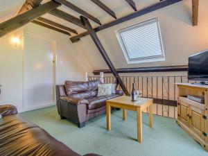 sala de estar con sofá de cuero y mesa en Apple Cottage-uk37361 en Lympsham