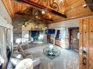 a living room with a couch and a fireplace at Tennox Stables - Uk39975 in Kilbirnie