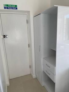 armadio bianco con porta e armadietto bianco di Annex B, a Studio flat in London a Carshalton