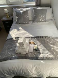 Una cama con bandeja con toallas y una botella. en Annex B, a Studio flat in London, en Carshalton