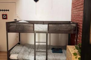 2 stapelbedden in een kamer met een bakstenen muur bij Montpetit condo 2 chambres in Montreal