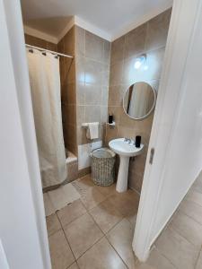 La salle de bains est pourvue d'un lavabo et d'un miroir. dans l'établissement Fin del Mundo Alojamientos, à Ushuaia