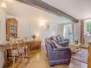 a living room with a couch and a table at Horseshoe Cottage-uk37360 in Lympsham
