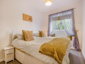 1 dormitorio con cama y ventana en Horseshoe Cottage-uk37360, en Lympsham