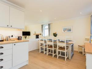 a kitchen and dining room with a table and chairs at High Auchenlarie Cottage in Carsluith