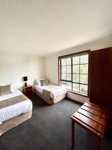 Habitación de hotel con 2 camas y ventana en Risby Cove Boutique Hotel, en Strahan