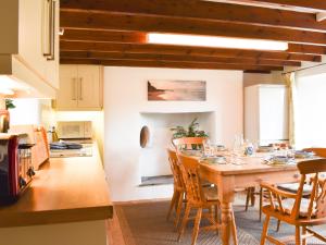 a kitchen and dining room with a wooden table and chairs at Madderhay - Uk43512 in Lostwithiel