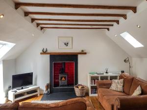 ein Wohnzimmer mit einem Sofa und einem Kamin in der Unterkunft Craigdarroch Cottage in Saint Fillans