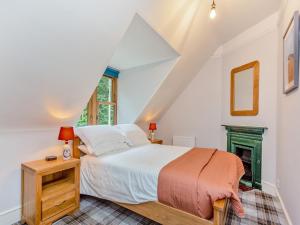 a bedroom with a bed and a fireplace at Gardeners Cottage in Huntly