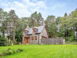 Gardeners Cottage في هونتلي: منزل كبير على حقل عشبي مع الأشجار