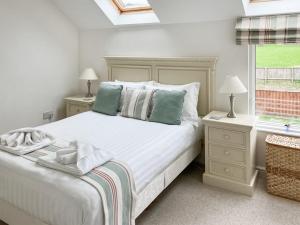 a white bedroom with a bed and a window at Delaware 7 in Yarmouth
