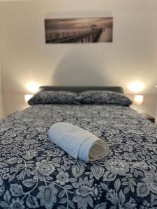 auf einem Bett liegt ein rollendes Handtuch in der Unterkunft Amaré Guest House in Neapel