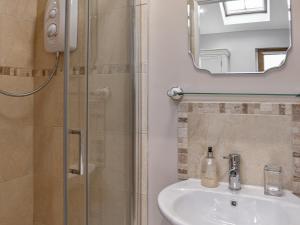 a bathroom with a shower and a sink and a mirror at Uk45886 - The Studio At Cross House in Kirkby Lonsdale