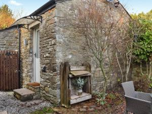 an old stone house with a sink in front of it at Uk45886 - The Studio At Cross House in Kirkby Lonsdale