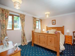 a bedroom with a large wooden bed and a window at The Arbour Folly - Uk46205 in Abbotskerswell