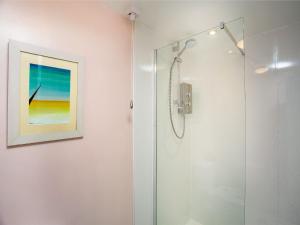a shower in a bathroom with a painting on the wall at The Arbour Folly - Uk46205 in Abbotskerswell