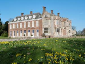 a large brick building with a field of flowers at Southbank in Mundesley