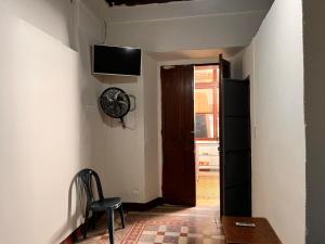 a hallway with a door and a chair and a television at Hotel Letona in Guatemala