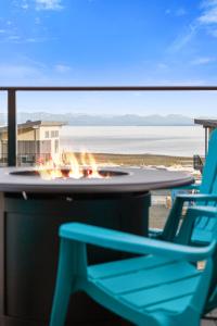 uma mesa e uma cadeira e uma fogueira na praia em Ocean View Townhouse #30 at THE BEACH HOUSE em Campbell River