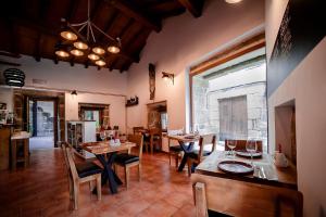 una sala da pranzo con tavoli e sedie in una stanza di Aldea Rural Pazos De Arenteiro a Pazos de Arenteiro