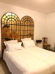 a bedroom with a large white bed with two windows at Central Park Apartment in Cannes