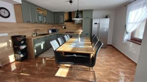 a kitchen with a wooden table and black chairs at Domček pod Borom in Suchá Hora