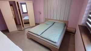 een kleine slaapkamer met een bed en een spiegel bij Domček pod Borom in Suchá Hora