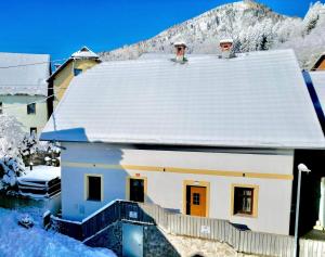 Casa blanca con techo cubierto de nieve en Jacobs Resort 4 Bedroom Private House, en Kranjska Gora