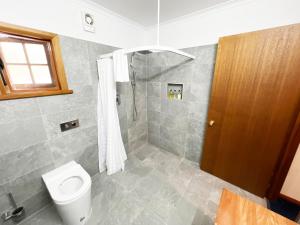 a bathroom with a shower and a toilet at Risby Cove Boutique Hotel in Strahan