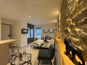 a bedroom with a bed and a stone wall at LE CALLOCH 2D - Studio 4 Étoiles - Quartier Gare - Wifi - Netflix in Quimper
