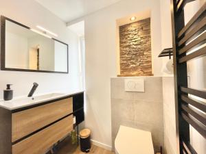 a bathroom with a sink and a mirror at LE CALLOCH 2D - Studio 4 Étoiles - Quartier Gare - Wifi - Netflix in Quimper +13 photos