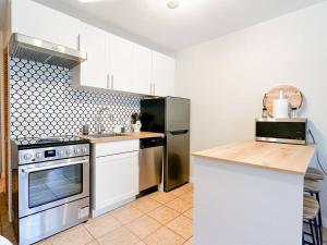 a kitchen with white cabinets and a stainless steel appliance at The Alpine Nest - 3 Beds - 4 Guests - Free Parking - Pool in Mont-Tremblant