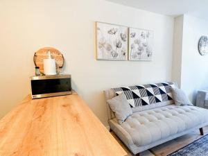 sala de estar con sofá y suelo de madera en The Alpine Nest - 3 Beds - 4 Guests - Free Parking - Pool, en Mont-Tremblant