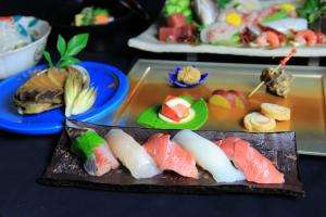 uma bandeja de sushi numa mesa com pratos de comida em Daitokuji Sushicho em Quioto
