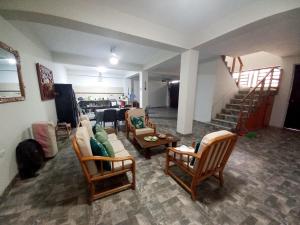 a living room with chairs and a couch and a staircase at Casa Entre Rocas y Veleros in Los Órganos