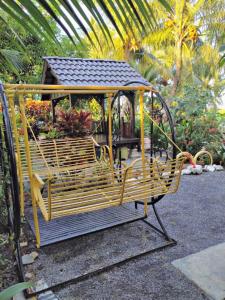 um banco de parque com um gazebo num jardim em Kubang Sepat HomeStay em Ayer Hitam