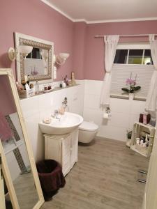 a bathroom with a sink and a toilet and a mirror at Sweet Home in Löhne