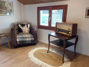 a room with a table with a radio and a chair at LaTerestone in Les Bayards