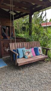 a wooden swing with pillows on it at Casas Del Mar in Manzanillo