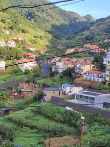 a small town on a hill with a road at Delfina`s House in Machico