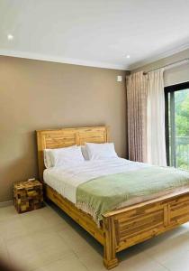 a bedroom with a large wooden bed and a window at Angel’s Nest Nelspruit in Nelspruit