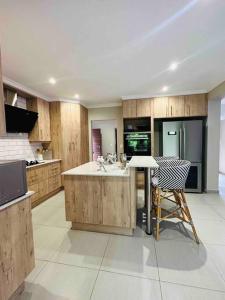 a kitchen with wooden cabinets and a table and chairs at Angel’s Nest Nelspruit in Nelspruit