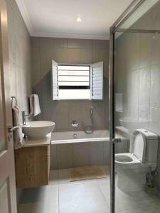a bathroom with a sink and a toilet and a shower at Angel’s Nest Nelspruit in Nelspruit