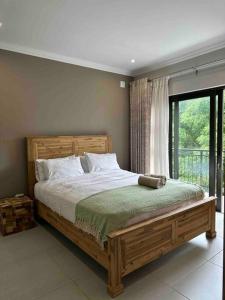 a bedroom with a wooden bed with a window at Angel’s Nest Nelspruit in Nelspruit