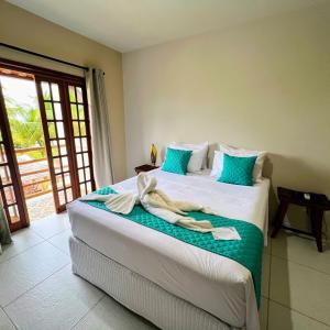 a bedroom with two beds with towels on them at Pousada Villa Bougainville Maragogi in Maragogi